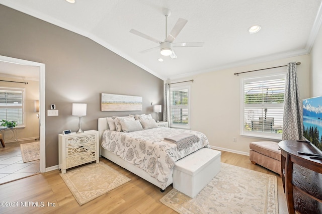 bedroom with ceiling fan, lofted ceiling, crown molding, and light hardwood / wood-style flooring