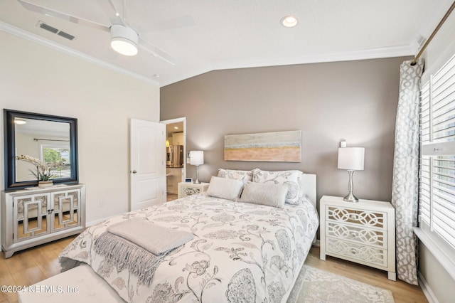 bedroom with light hardwood / wood-style floors, vaulted ceiling, ceiling fan, and ornamental molding