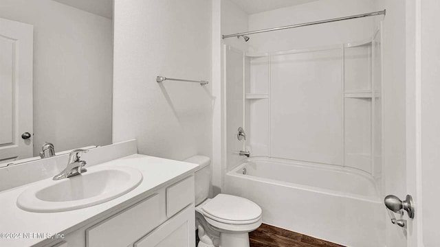 full bathroom featuring vanity, hardwood / wood-style floors, washtub / shower combination, and toilet