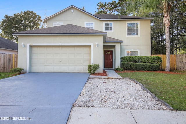 front of property with a garage and a front lawn