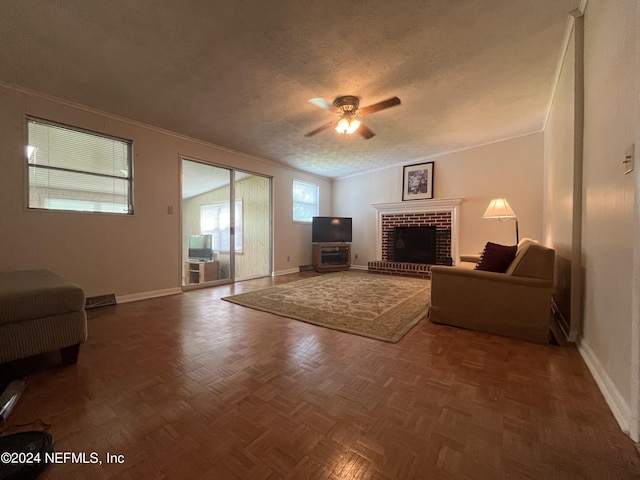 living room featuring a textured ceiling, parquet flooring, ceiling fan, ornamental molding, and a brick fireplace