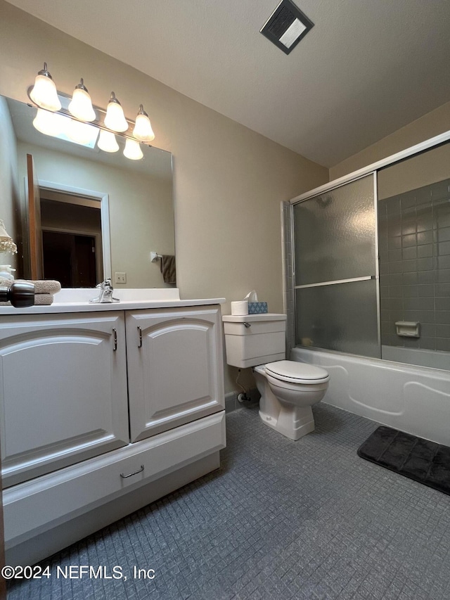 full bathroom with bath / shower combo with glass door, toilet, and vanity