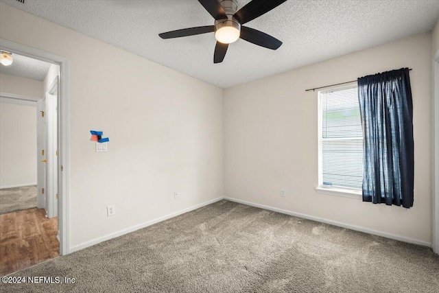 carpeted spare room with ceiling fan and a textured ceiling