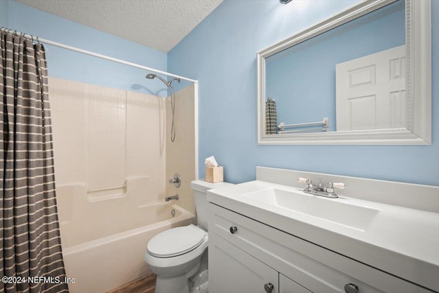 full bathroom featuring shower / bath combo, vanity, a textured ceiling, and toilet