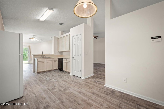 kitchen with white refrigerator, ceiling fan, kitchen peninsula, a textured ceiling, and light wood-type flooring