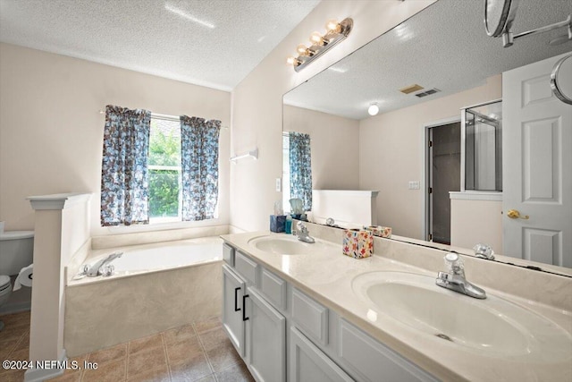 full bathroom featuring vanity, toilet, a textured ceiling, and separate shower and tub