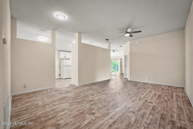 empty room featuring ceiling fan, a textured ceiling, and light wood-type flooring