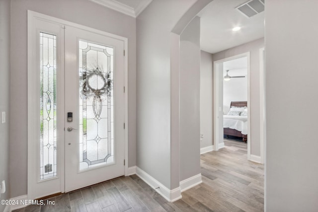 entryway featuring light wood-type flooring and ornamental molding