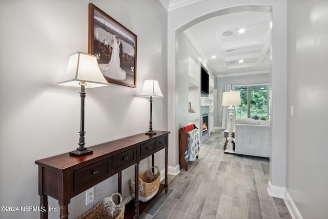 hall featuring beam ceiling, light wood-type flooring, crown molding, and coffered ceiling