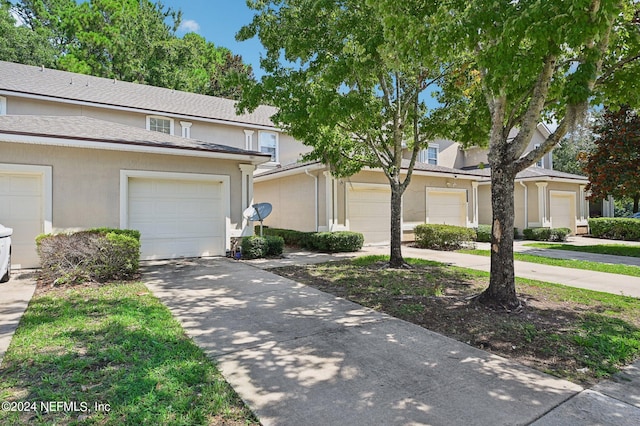 view of property with concrete driveway and stucco siding