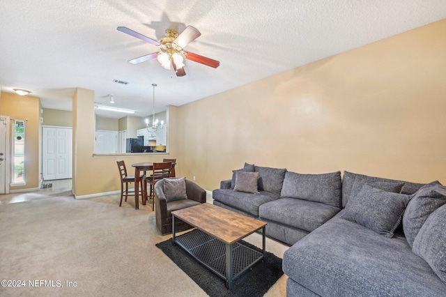 living room with light carpet, ceiling fan with notable chandelier, and a textured ceiling