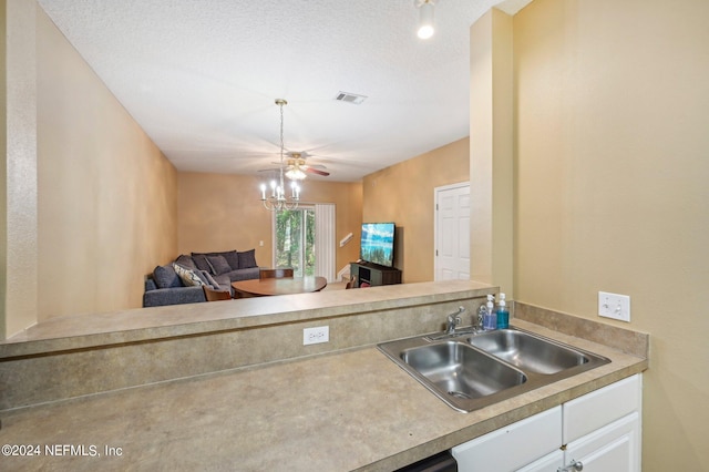 kitchen with sink, white cabinetry, a textured ceiling, and ceiling fan