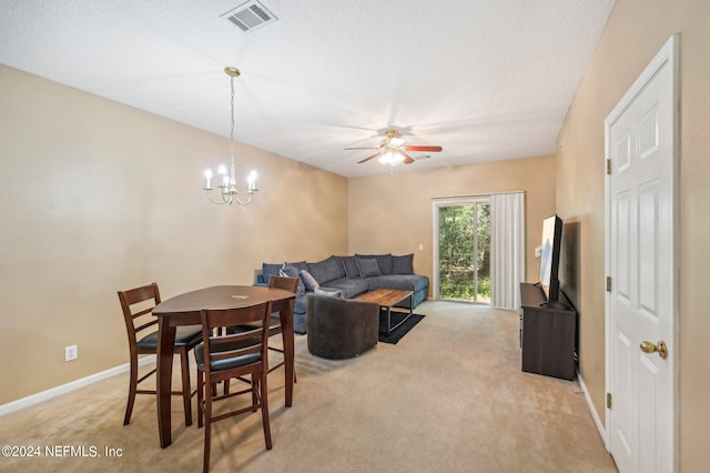 carpeted living room featuring ceiling fan with notable chandelier and a textured ceiling