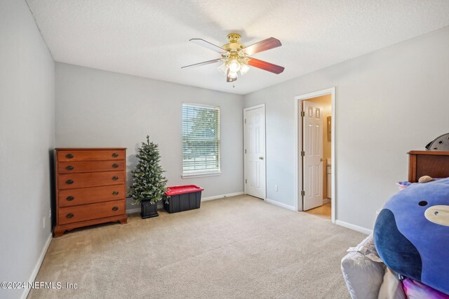 interior space featuring light carpet, a textured ceiling, and ceiling fan