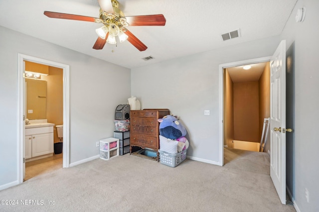 bedroom featuring light carpet, connected bathroom, and ceiling fan