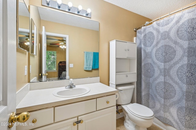 bathroom with a textured ceiling, toilet, vanity, and ceiling fan