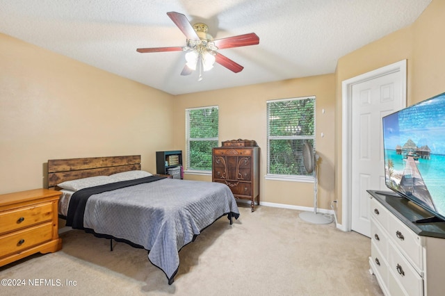 carpeted bedroom with a textured ceiling and ceiling fan