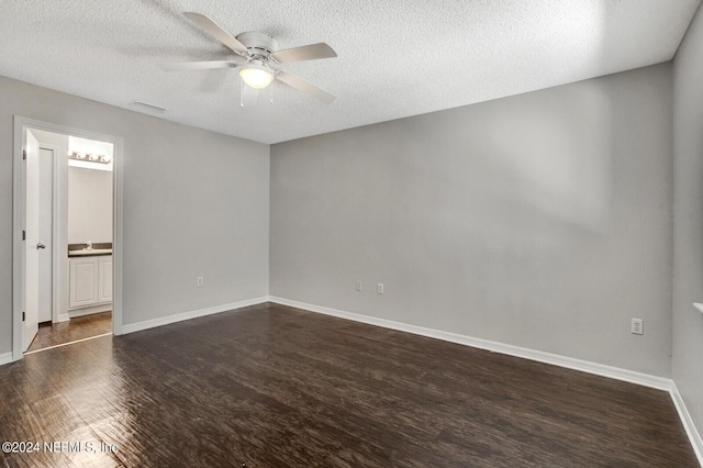 unfurnished bedroom featuring connected bathroom, ceiling fan, dark wood-type flooring, and a textured ceiling