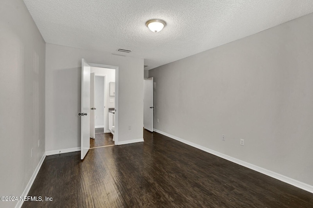 unfurnished bedroom featuring dark hardwood / wood-style flooring and a textured ceiling