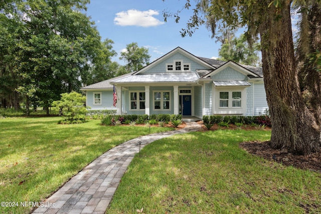 view of front of home featuring covered porch and a front lawn