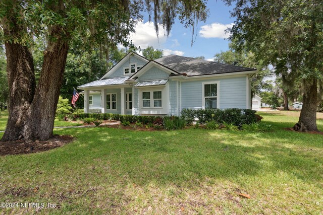 view of front of home featuring a standing seam roof, metal roof, and a front lawn