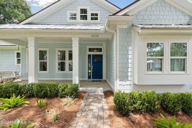 property entrance featuring a standing seam roof, metal roof, and a porch