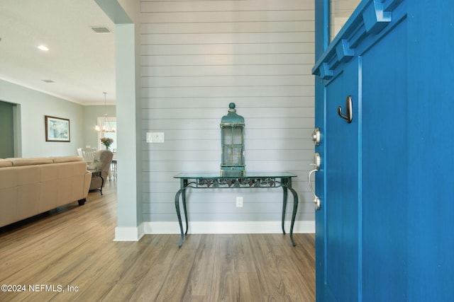 interior space featuring ornamental molding, wood finished floors, visible vents, and baseboards