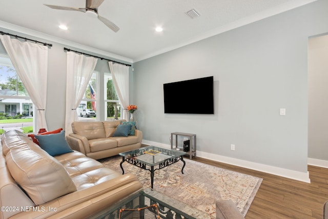 living area featuring baseboards, visible vents, ceiling fan, wood finished floors, and crown molding