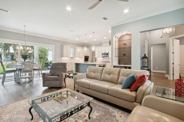 living room with recessed lighting, light wood-style flooring, visible vents, and ceiling fan with notable chandelier