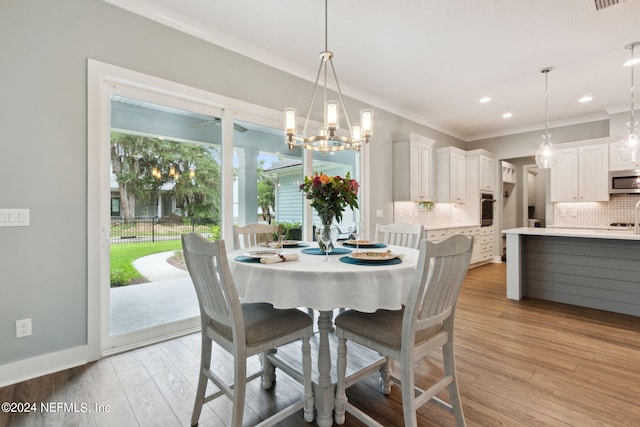 dining room with baseboards, ornamental molding, light wood-type flooring, a notable chandelier, and recessed lighting