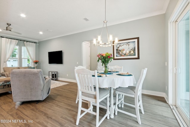 dining area with light wood finished floors, ornamental molding, visible vents, and baseboards