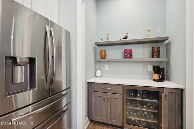 bar with wine cooler and stainless steel fridge with ice dispenser