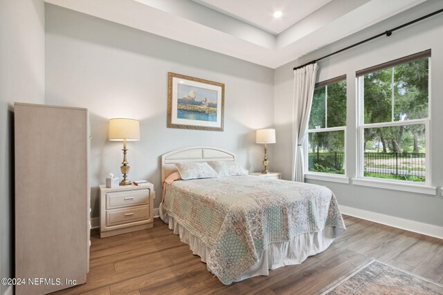 bedroom with recessed lighting, wood finished floors, and baseboards