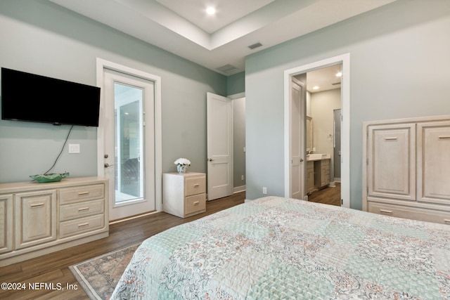 bedroom featuring access to exterior, visible vents, ensuite bath, and wood finished floors