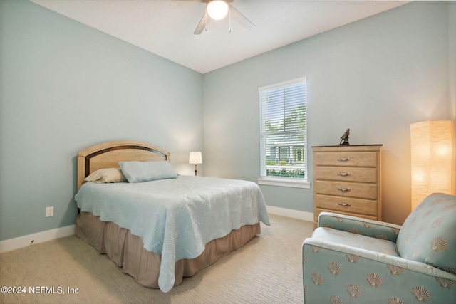 bedroom featuring light colored carpet, ceiling fan, and baseboards