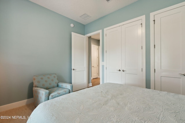 bedroom with a closet, visible vents, and baseboards