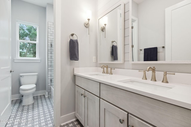 bathroom featuring baseboards, a sink, toilet, and double vanity