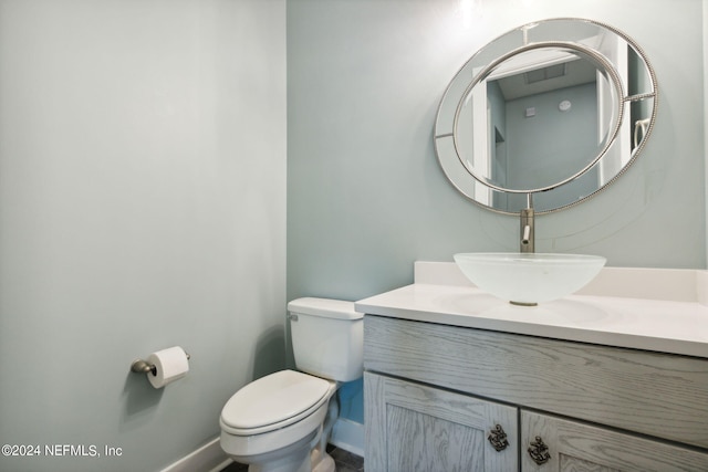 bathroom with vanity, toilet, and baseboards