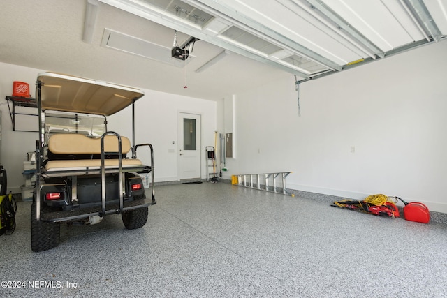 garage with baseboards, electric panel, and a garage door opener