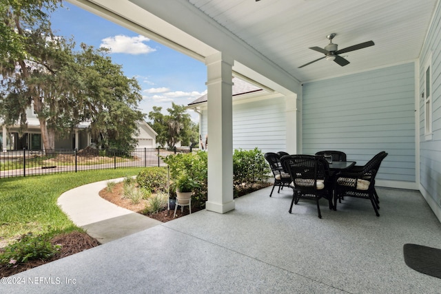 view of patio / terrace featuring fence, outdoor dining area, and a ceiling fan