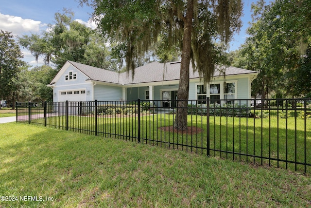 ranch-style house with a garage, driveway, a fenced front yard, and a front yard