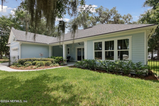 ranch-style home with a garage, ceiling fan, fence, and a front yard