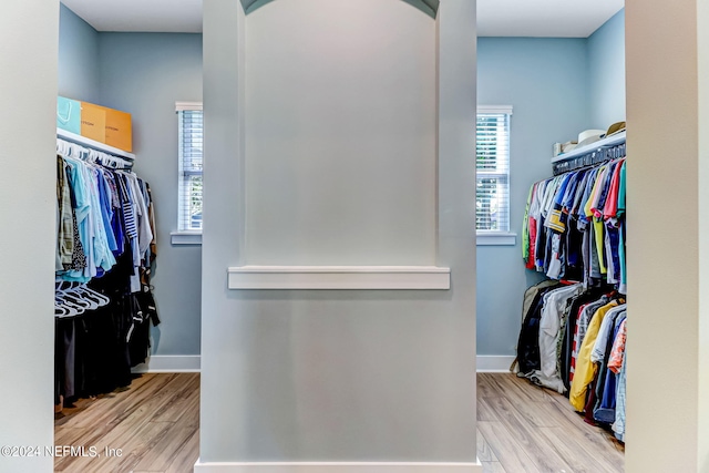 walk in closet with wood finished floors