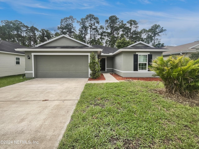 ranch-style home featuring a garage and a front lawn