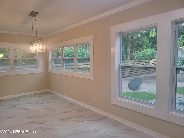 spare room with ornamental molding, marble finish floor, and baseboards