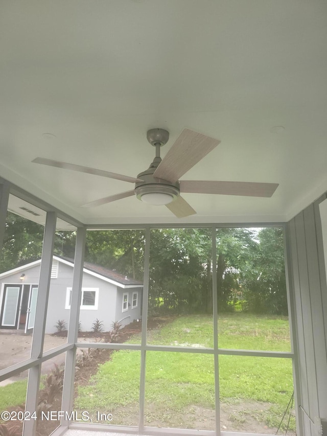 unfurnished sunroom featuring ceiling fan