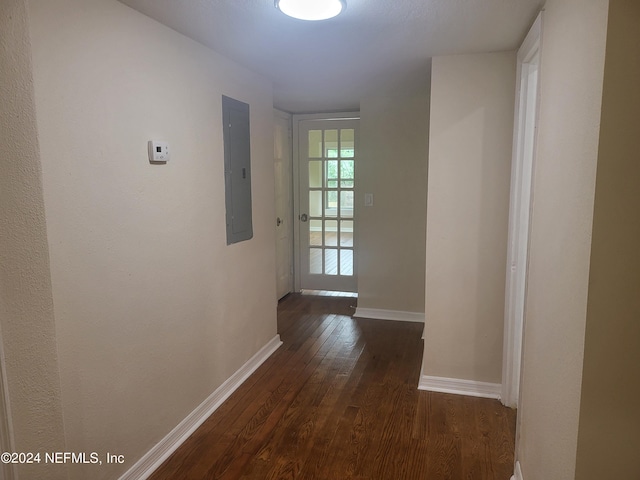 hall with electric panel, baseboards, and dark wood-style flooring