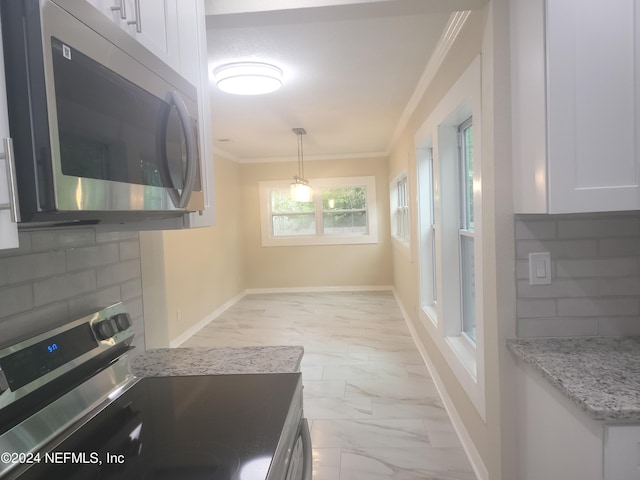 kitchen with white cabinetry, ornamental molding, appliances with stainless steel finishes, and hanging light fixtures