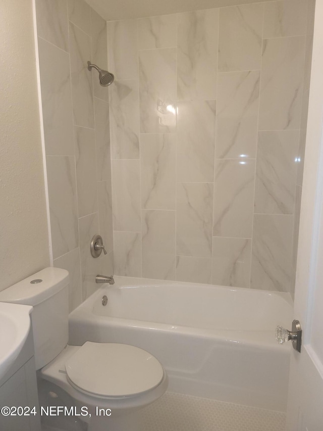 full bathroom featuring tiled shower / bath, vanity, and toilet