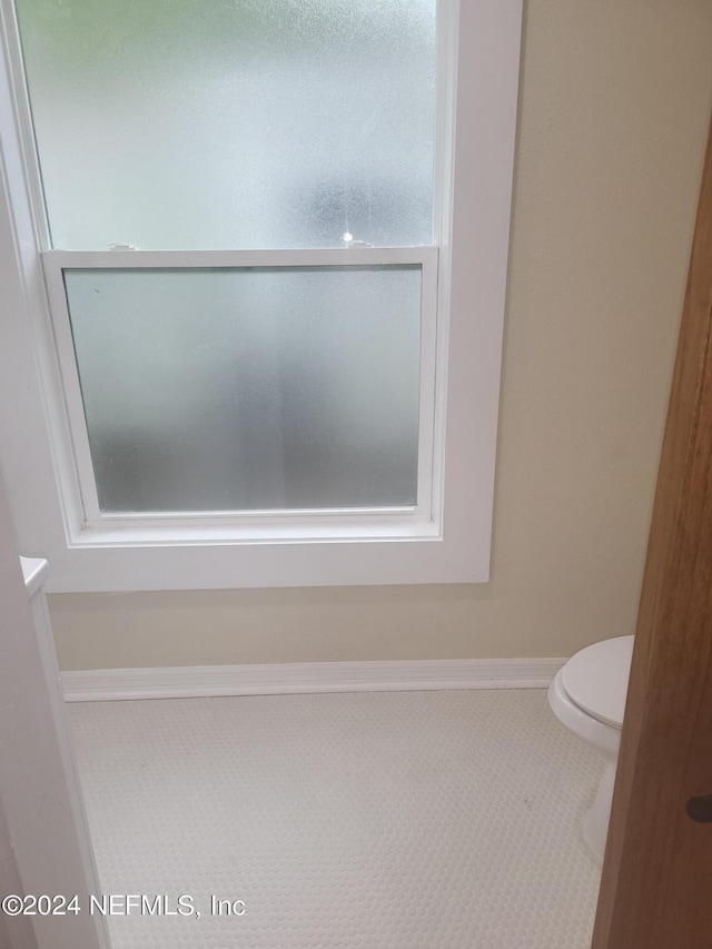 bathroom with toilet and baseboards